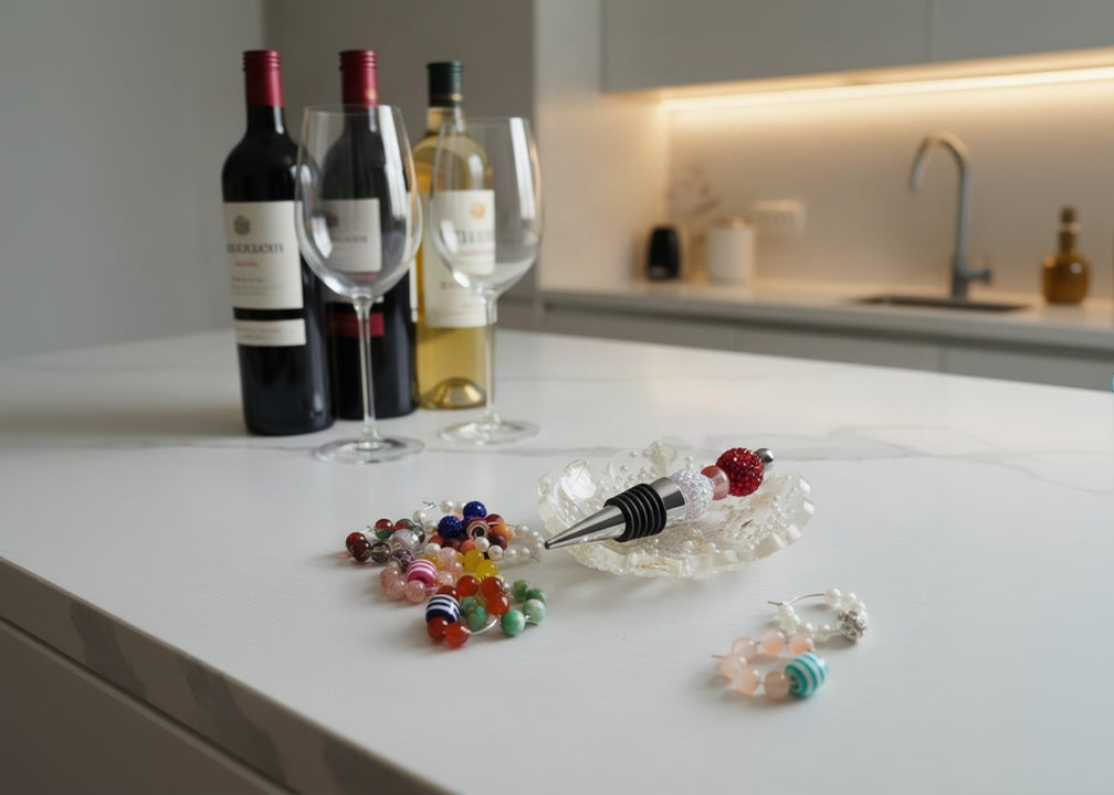 A set of colorful beaded wine stoppers displayed on a light gray surface, with one stopper resting in a clear acrylic dish filled with small white beads.